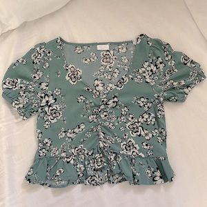 Cropped blouse with puff sleeves and ruffle at bottom.  Also scrunches in front